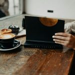 a woman sitting at a table using a laptop computer