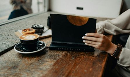a woman sitting at a table using a laptop computer