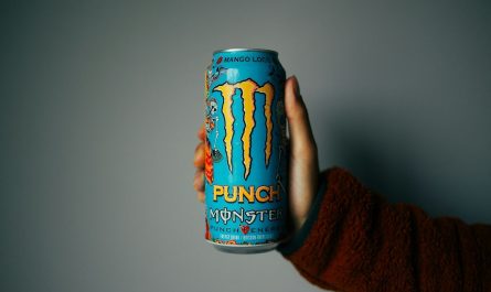 person holding blue and orange can